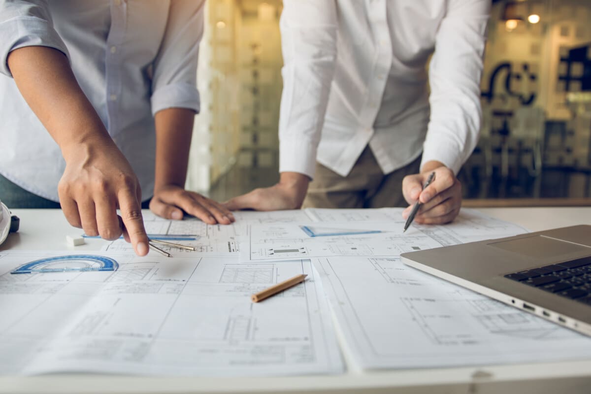 Deux professionnels évaluant la valeur d’un immeuble pour assurer la conformité aux exigences de la Loi 16 concernant les copropriétés