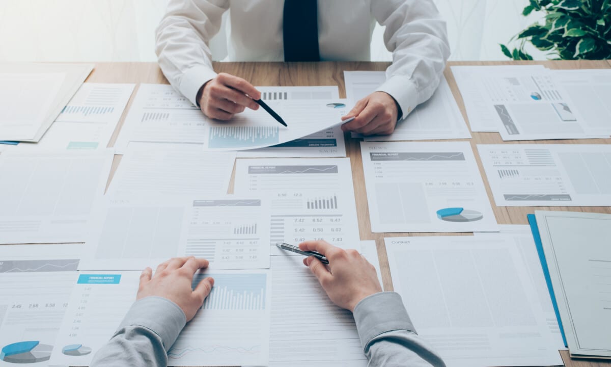 Deux professionnels analysant des rapports financiers pour évaluer la conformité à la Loi 16 concernant la gestion des copropriétés